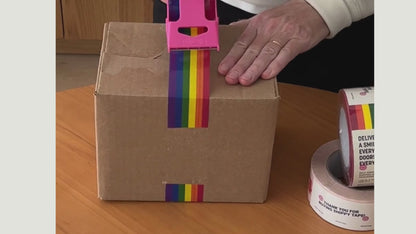 A person shows support for the LGBTQ+ community by taping a box with rainbow pride flag craft tape.