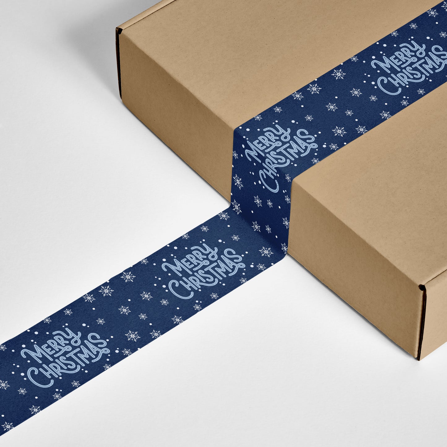 Box sealed with navy blue Merry Christmas snowflake-designed packing tape.