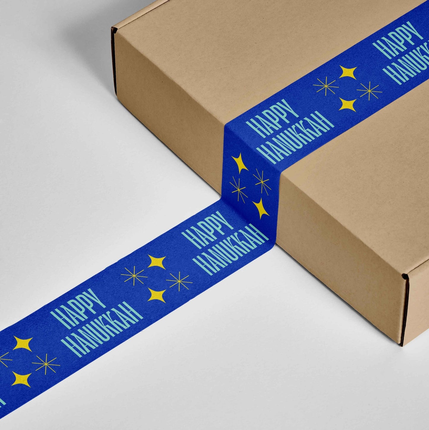 Festively designed 'Happy Hanukkah' shipping tape in blue and yellow adorning a gift package.